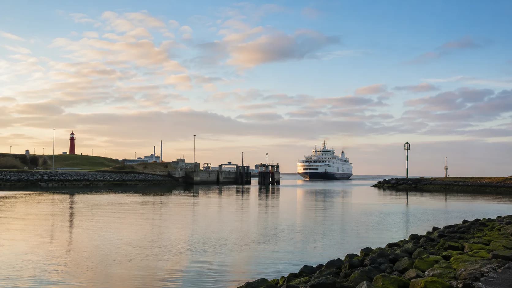 Haven van Den Helder bij zonsopgang met de veerboot richting Texel en de vuurtoren